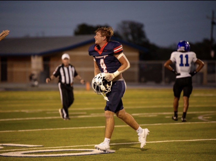 Carter Smith #4 walking off the field holding his helmet after a play