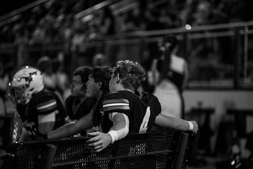 Carter Smith #4 on the sideline bench during a Madisonville Mustangs football game